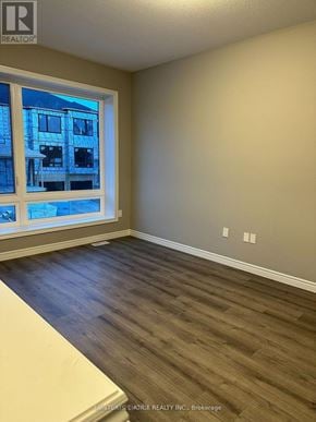 Guelph (Grange Road) townhouse for rent - A room with a window showing a building outside.