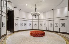 Toronto (Church-Yonge Corridor) condo for rent - A chandelier hangs from the ceiling in a hallway with framed pictures on the wall.