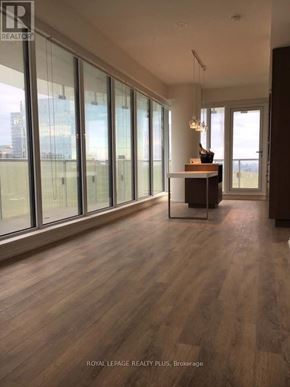Toronto (Church-Yonge Corridor) condo for rent - A spacious room with wooden flooring and large windows.