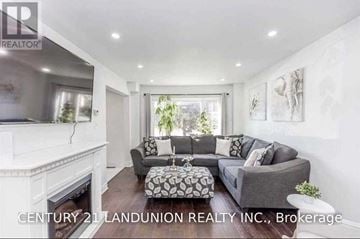 Barrie (West Bayfield) apartment for rent - A living room with a grey couch and a fireplace.