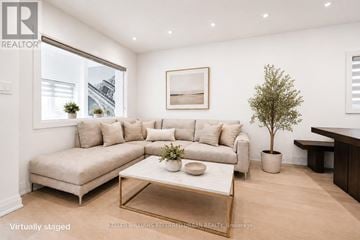 Toronto (Danforth Village-East York) apartment for rent - A living room with a couch, coffee table, and a potted plant.
