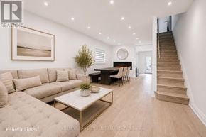 Toronto (Danforth Village-East York) apartment for rent - A living room with a couch, a coffee table, and a staircase.
