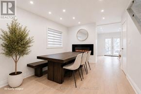 Toronto (Danforth Village-East York) apartment for rent - A modern dining room with a fireplace and a round mirror on the wall.