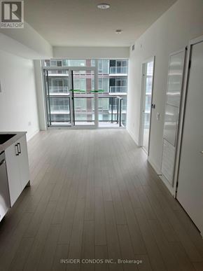 Toronto (Humber Heights) condo for rent - A spacious kitchen and living room with a view of a building outside the window.