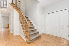 Ottawa apartment for rent - A wooden staircase with a carpeted runner leads up to a landing with white walls and doors.