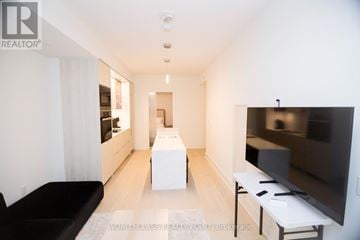 Toronto (Annex) condo for rent - A modern living room with a black couch and a flat screen TV.
