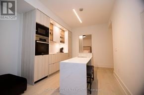 Toronto (Annex) condo for rent - A modern kitchen with a white island in the middle.