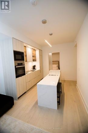 Toronto (Annex) condo for rent - A modern kitchen with wooden cabinets and a white island.