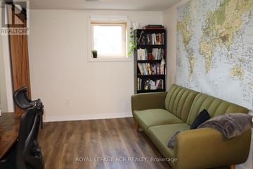 Caledon (Bolton North) apartment for rent - A living room with a green sofa and a world map on the wall.