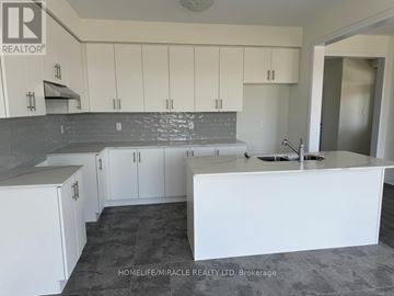 Brantford apartment for rent - A kitchen with white cabinets and a grey countertop.