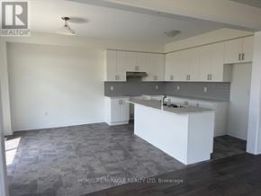 Brantford apartment for rent - A kitchen with white cabinets and a grey island.