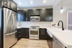 Hamilton (Gibson) apartment for rent - A modern kitchen with a stainless steel refrigerator and black cabinets.