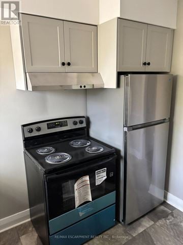 Niagara Falls (Downtown) multi-family for rent - A stainless steel refrigerator and stove in a kitchen.