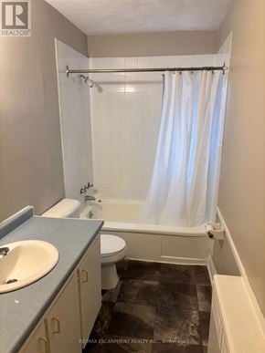 Niagara Falls (Downtown) multi-family for rent - A bathroom with a toilet, sink, and bathtub.
