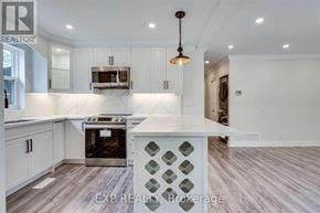 Hamilton (Eastmount) apartment for rent - A kitchen with white cabinets and a wooden floor.