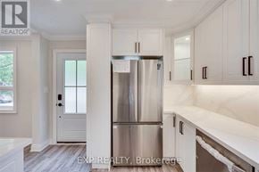 Hamilton (Eastmount) apartment for rent - A kitchen with white cabinets and a stainless steel refrigerator.