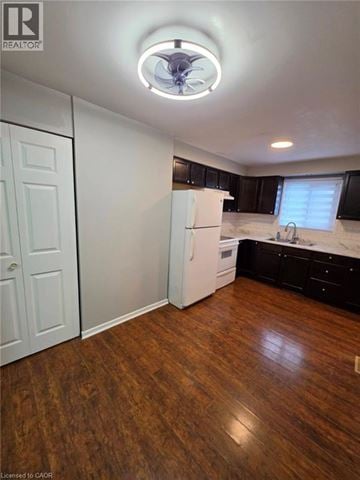 Kitchener townhouse for rent - A kitchen with a white fridge and wooden floors.