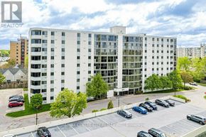 London South (South O) condo for rent - A large white building with a parking lot in front.