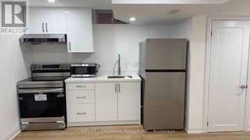 Markham (Middlefield) apartment for rent - A kitchen with white cabinets and a stainless steel refrigerator.