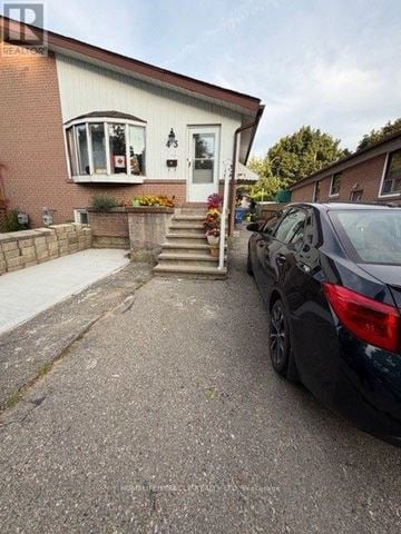Brampton (Brampton South) apartment for rent - A black car is parked in front of a house.