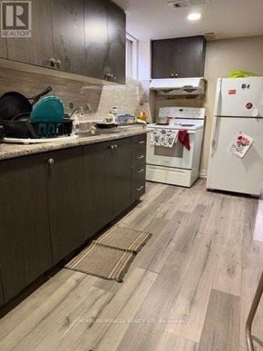 Brampton (Brampton South) apartment for rent - A kitchen with a white fridge and wooden floors.
