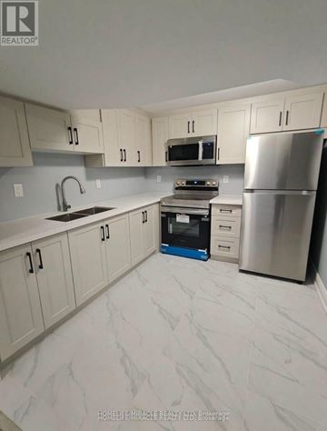Cambridge apartment for rent - A kitchen with a refrigerator, oven, and sink.