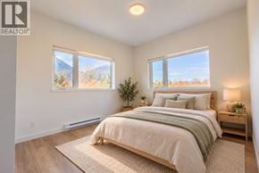 Squamish apartment for rent - A bedroom with a large bed and a view of the outdoors through the windows.