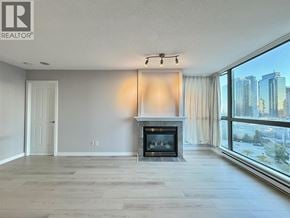 Burnaby apartment for rent - A living room with a fireplace and a view of the city.