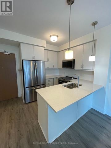 Oakville (Oa Rural Oakville) condo for rent - A kitchen with a white countertop and a stainless steel refrigerator.