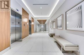Toronto (Mimico) condo for rent - A long hallway with a bench and pictures on the wall.