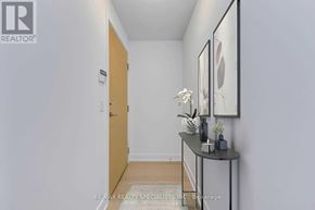 Toronto (Mimico) condo for rent - A hallway with a table and two framed pictures on the wall.