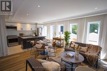 Toronto (Rockcliffe-Smythe) multi-family for rent - A well-lit, modern kitchen and living room with a dining table set for two.