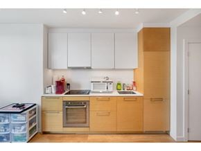 Surrey apartment for rent - A kitchen with wooden cabinets and a white fridge.