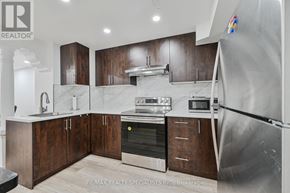 Brampton (Bramalea North Industrial) apartment for rent - A modern kitchen with dark wood cabinets and stainless steel appliances.