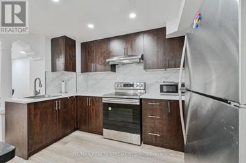 Brampton (Bramalea North Industrial) apartment for rent - A modern kitchen with dark wood cabinets and stainless steel appliances.