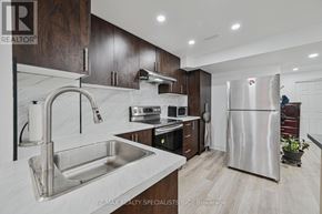 Brampton (Bramalea North Industrial) apartment for rent - A modern kitchen with a stainless steel refrigerator and a marble countertop.