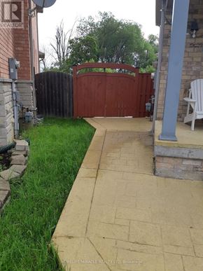 Brampton (Bram East) apartment for rent - A brick house with a gate and a white chair.