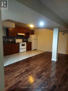 Brampton (Bram East) apartment for rent - A kitchen with wooden floors and white appliances.