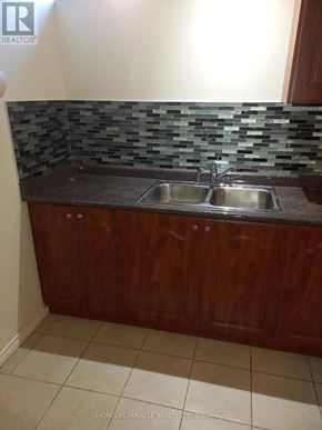 Brampton (Bram East) apartment for rent - A kitchen with a sink and wooden cabinets.