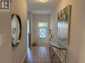 Kawartha Lakes (Bobcaygeon) townhouse for rent - A hallway with a glass table and a painting on the wall.