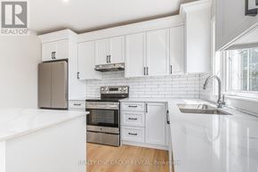 Clarington (Bowmanville) triplex for rent - A white kitchen with a sink and cabinets.