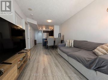 Toronto (Niagara) condo for rent - A living room with a grey couch and a television.