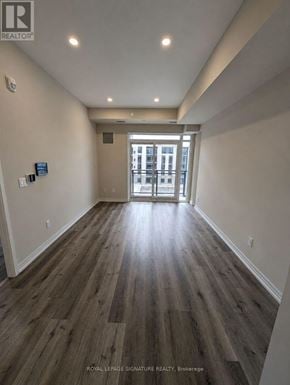 St. Catharines (E. Chester) condo for rent - A hallway with wood flooring and white walls leading to a door.