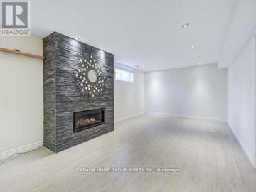 Toronto (Bathurst Manor) apartment for rent - A modern living room with a fireplace and a large mirror on the wall.