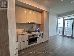 Vaughan (Vaughan Corporate Centre) condo for rent - A kitchen with wooden cabinets and a countertop with a laptop on it.