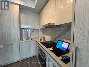 Vaughan (Vaughan Corporate Centre) condo for rent - A laptop is open on a kitchen counter displaying a blue screen.