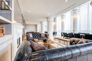 Toronto (Yonge-Eglinton) condo for rent - A living room with a black leather couch and a wooden coffee table.