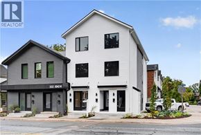 Hamilton apartment for rent - A white two story house with a black awning and a sign that says 332 KING.