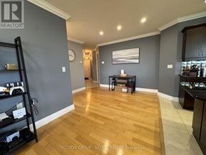 London East (East F) condo for rent - A room with wooden flooring and a grey wall with a clock on it.