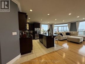 London East (East F) condo for rent - A modern kitchen with dark wood cabinets and a large island.